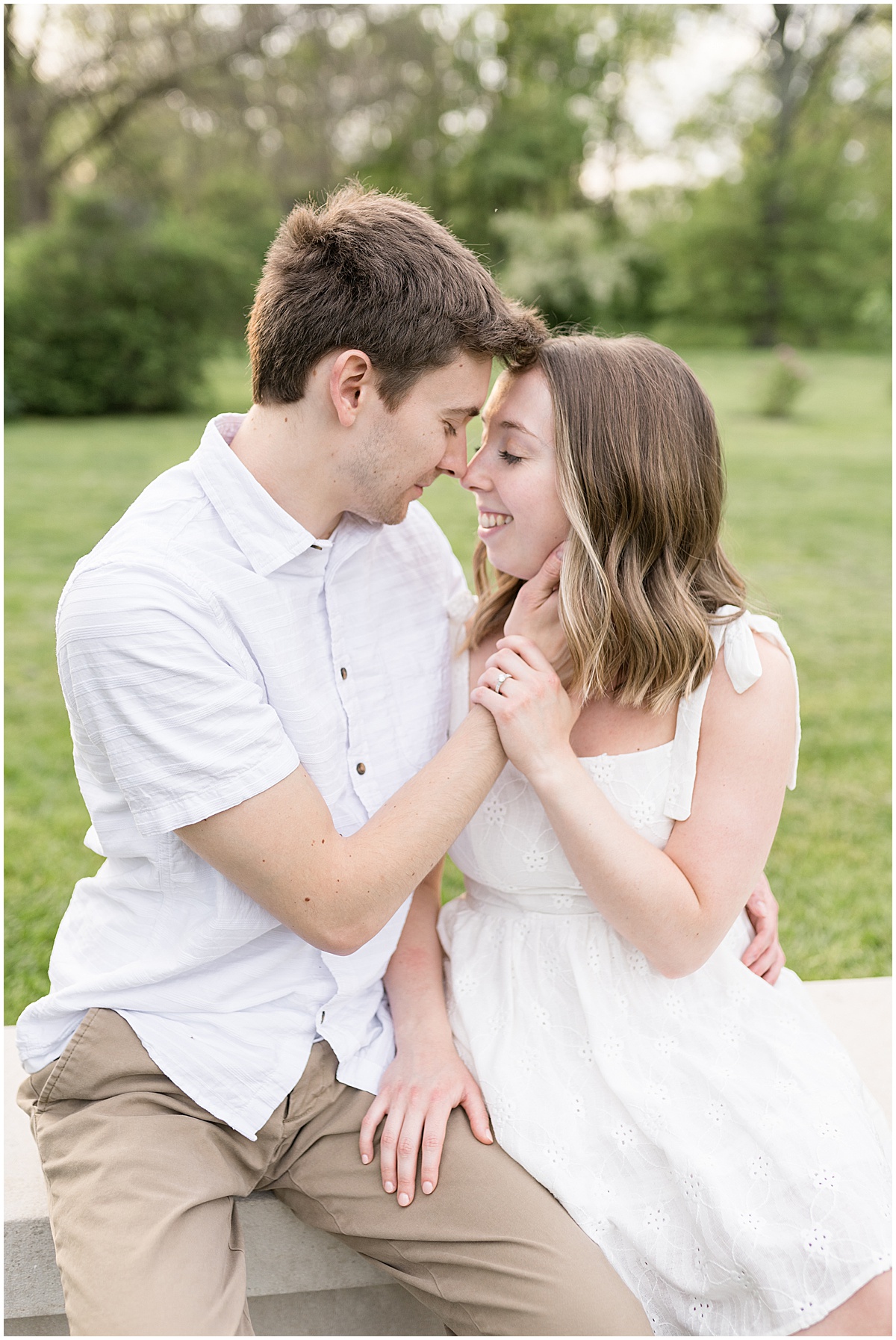 Couple touch noses during engagement photos at Holcomb Gardens in Indianapolis.