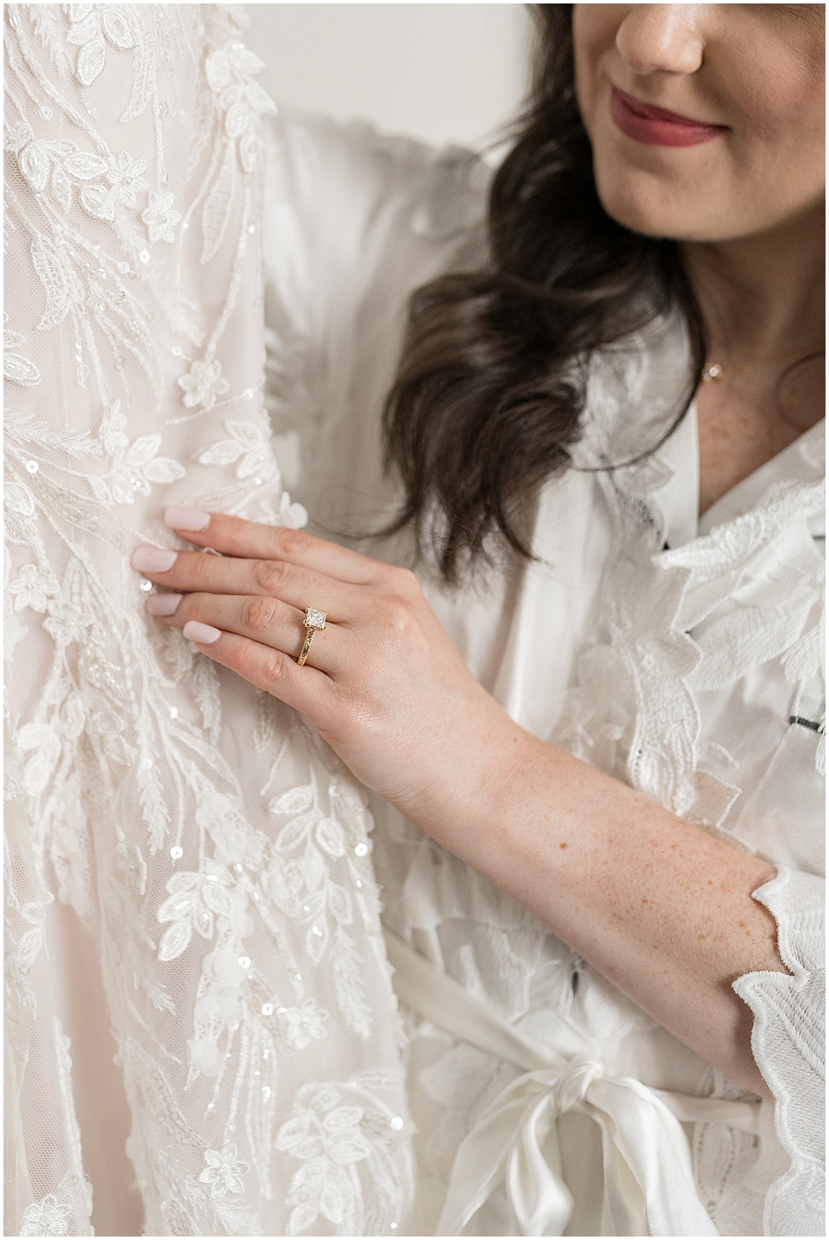 Closeup of bride's ring while she holds wedding dress before Historic Saint Joseph Hall wedding in Indianapolis