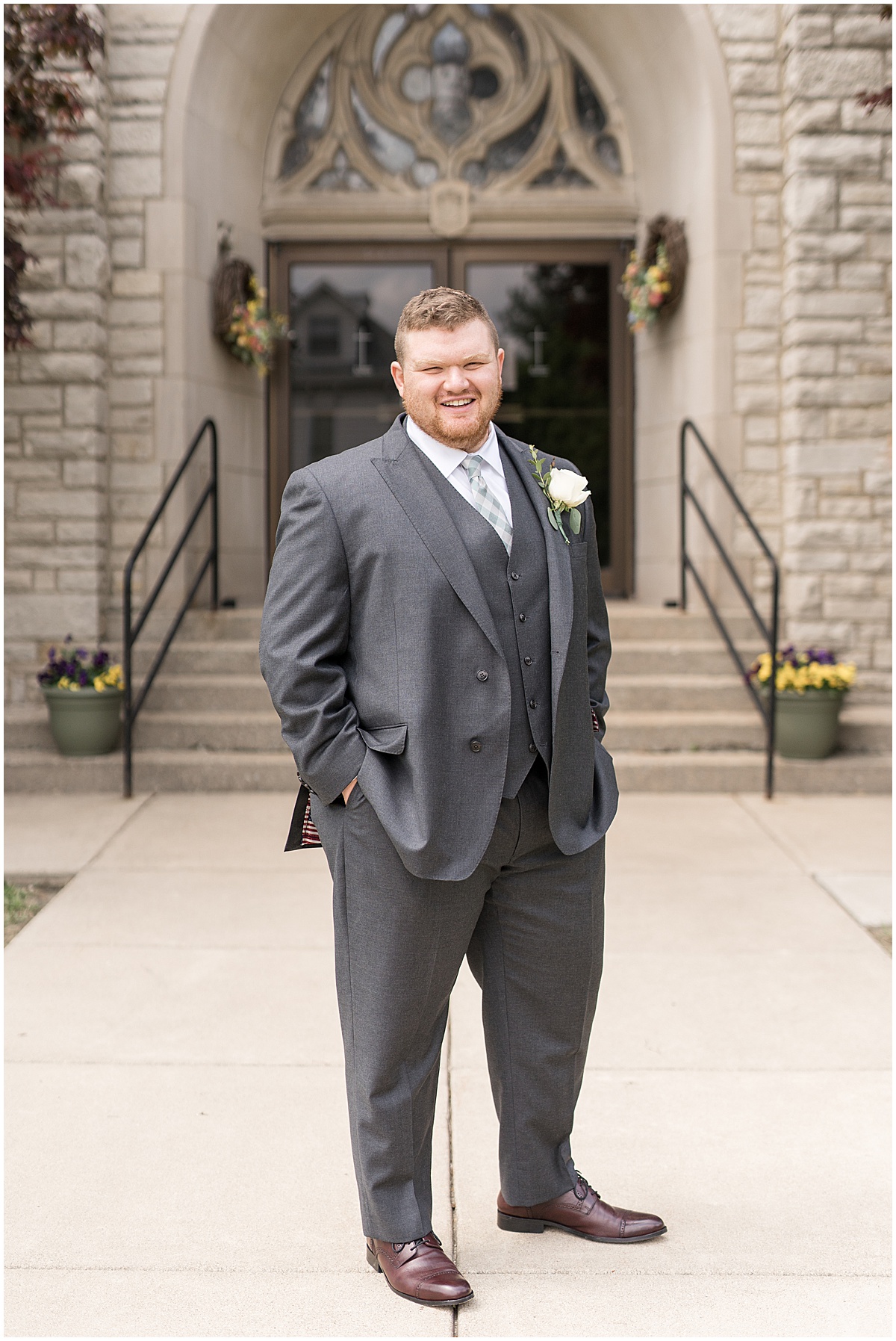 Groom standing outside before wedding at St. Augustine Catholic Church in Rensselaer, Indiana