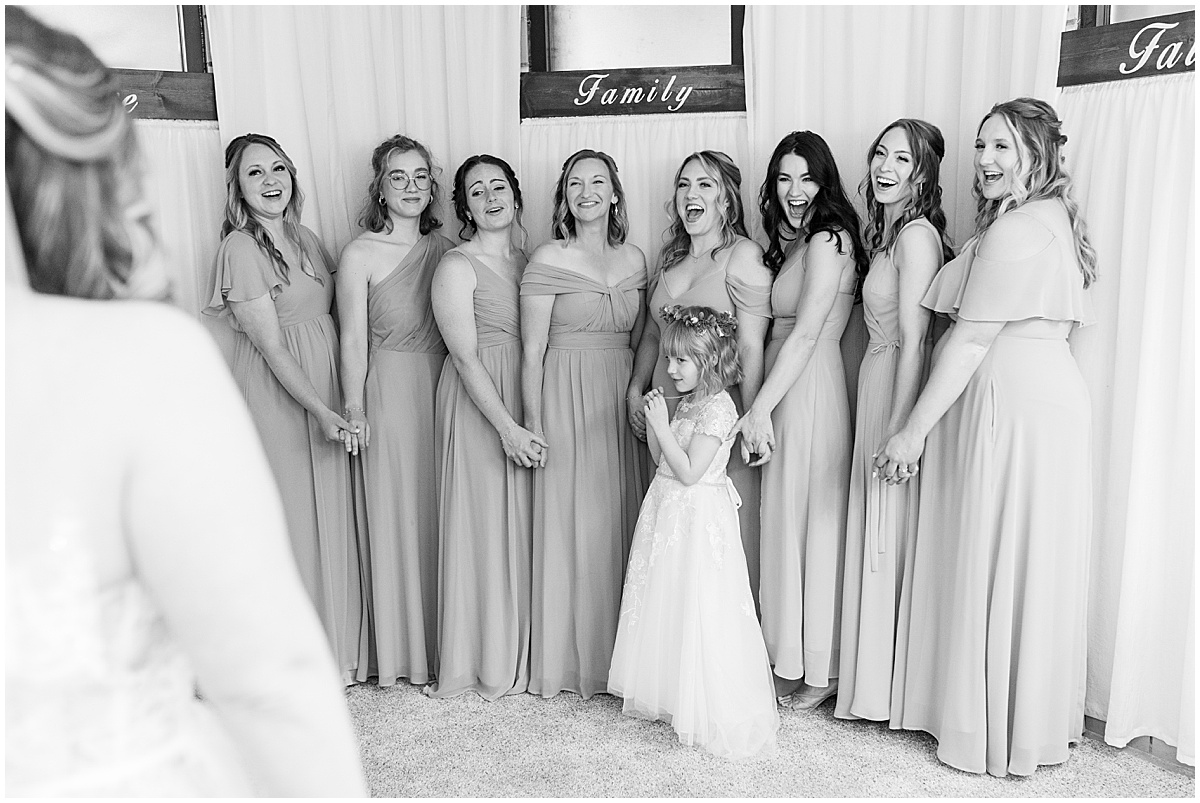 Bridesmaids reaction to bride at wedding at St. Augustine Catholic Church in Rensselaer, Indiana