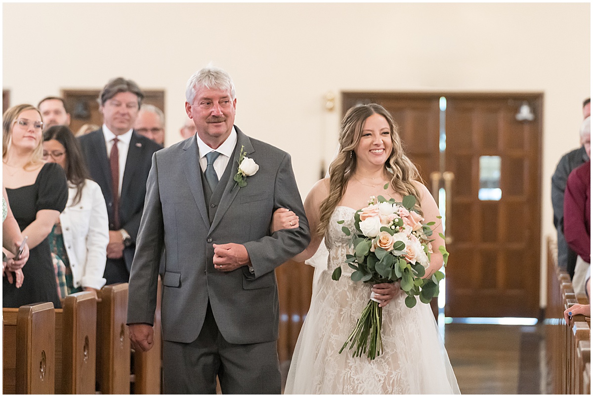 Bride walks down aisle at wedding at St. Augustine Catholic Church in Rensselaer, Indiana