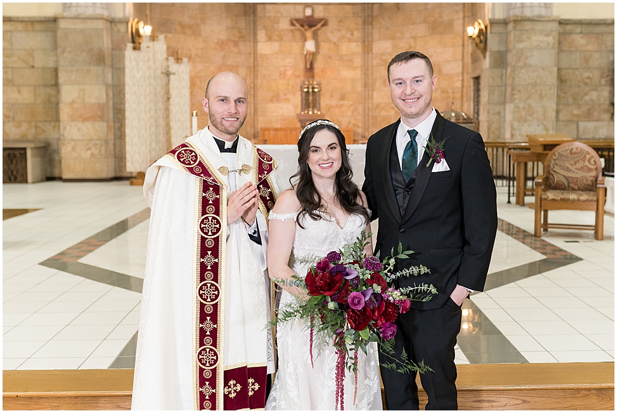 Bride and groom with priest after Saint Mary's Catholic Cathedral wedding in downtown Indianapolis