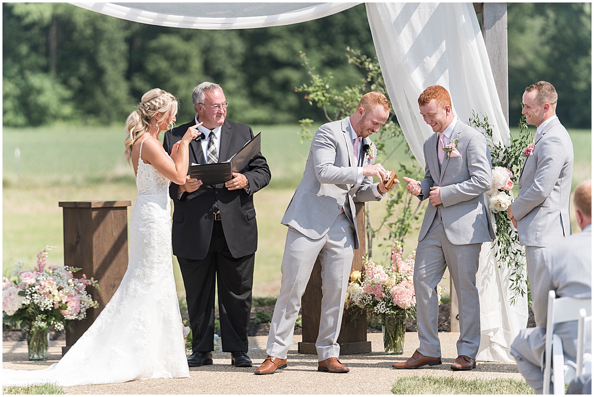 Groom gets ring during wedding at New Journey Farms in Lafayette, Indiana