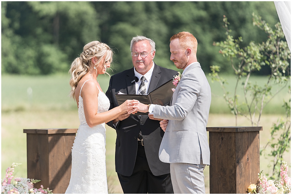 Couple exchanges rings during wedding at New Journey Farms in Lafayette, Indiana