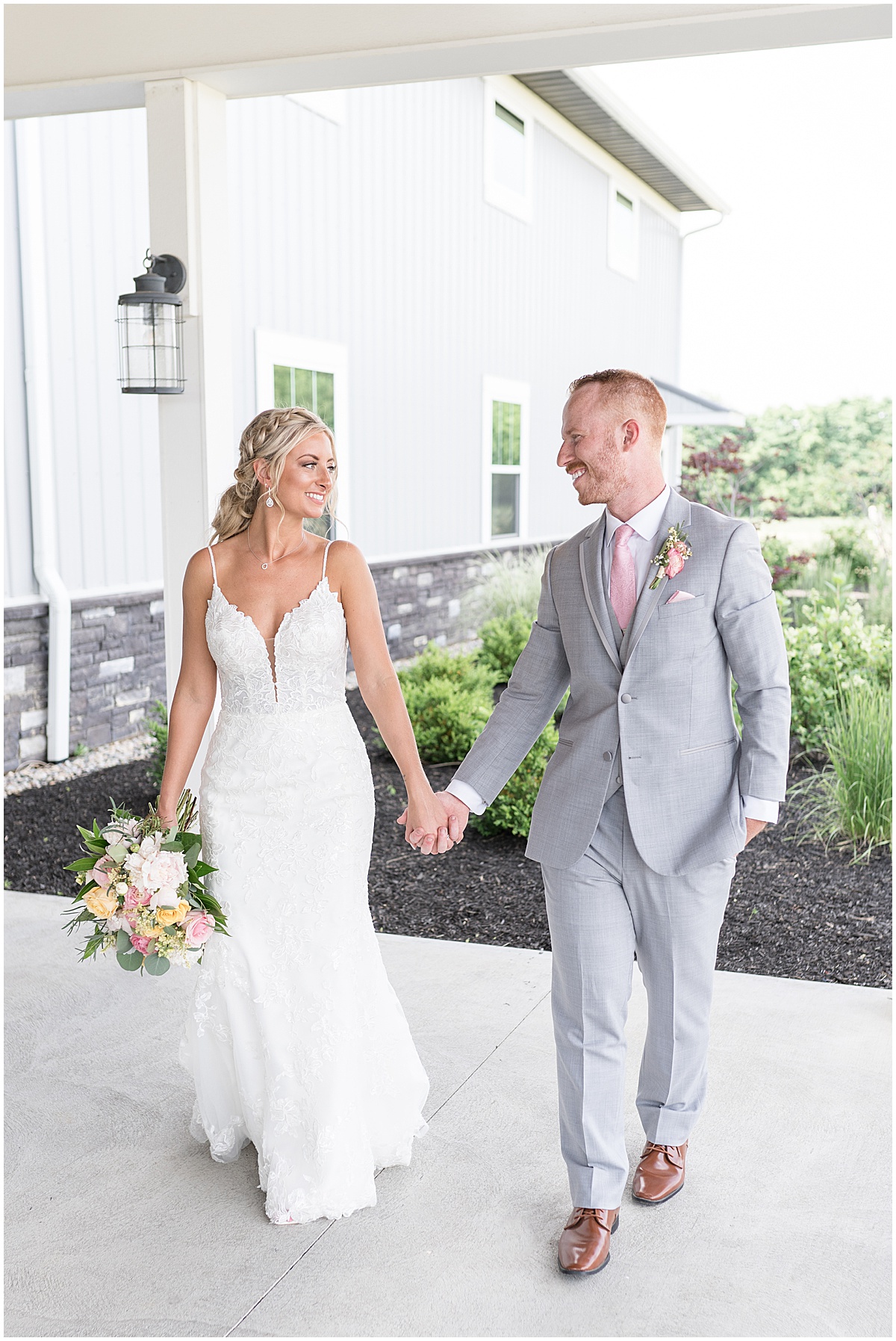 Newlyweds hold hands outside wedding at New Journey Farms in Lafayette, Indiana