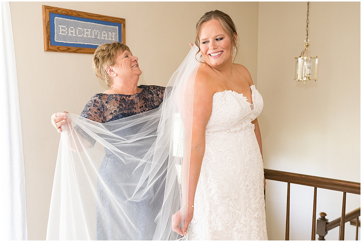 Bride gets help with putting on veil at St. Joseph Catholic Church in Jasper, Indiana