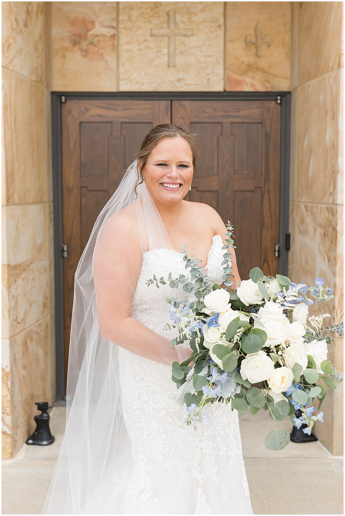 Bride stands in front of church door at St. Joseph Catholic Church in Jasper, Indiana
