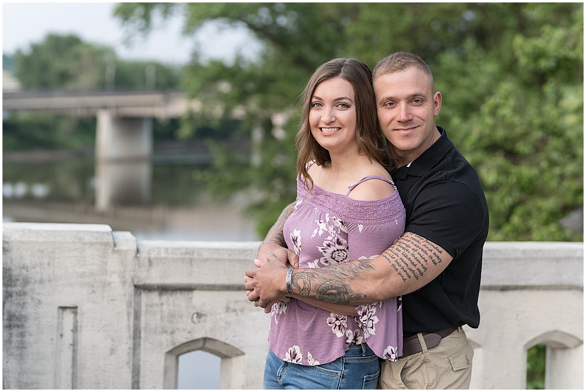 Couple in front of historic bridge during sunrise engagement photos in Lafayette, Indiana at Tapawingo Park