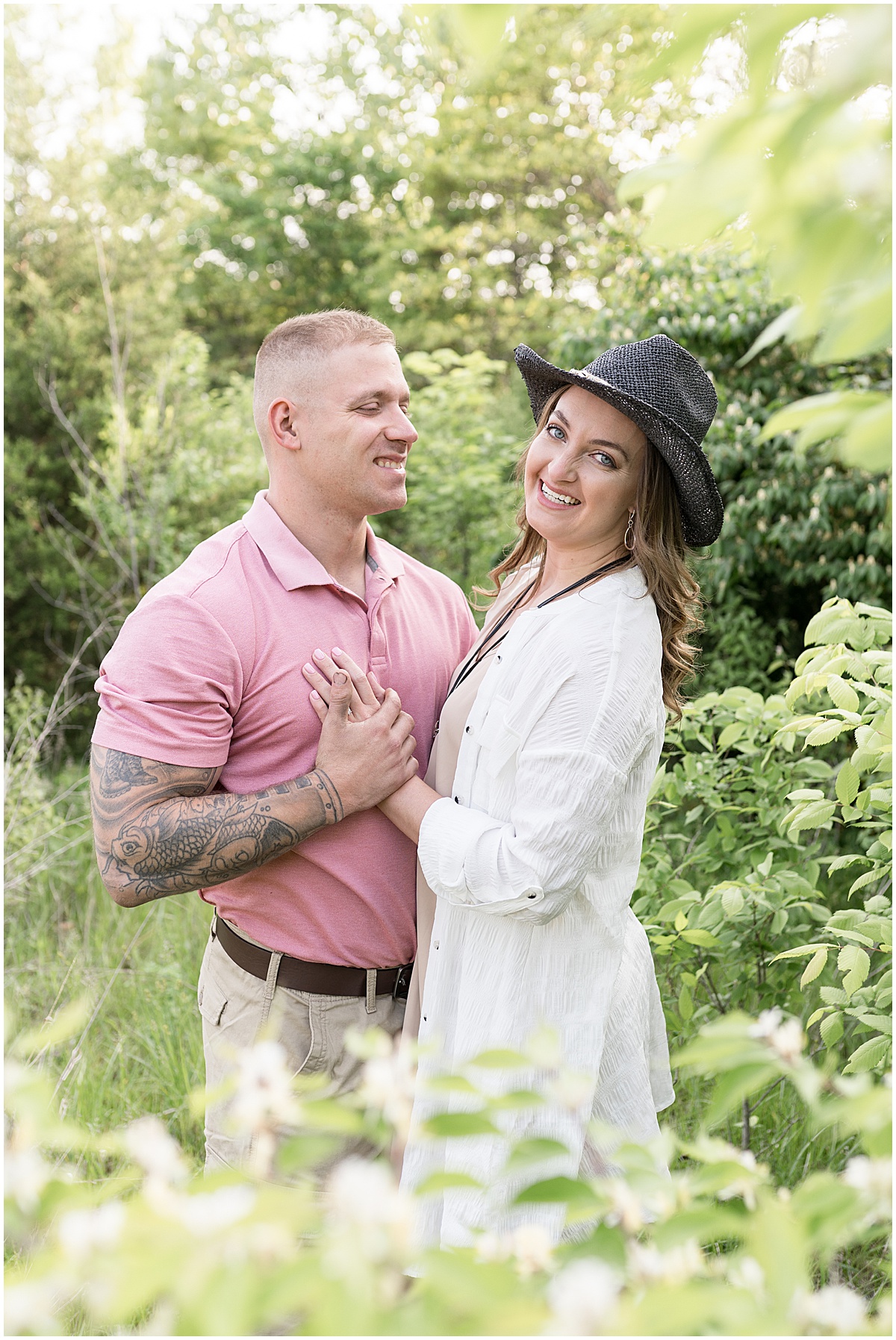 Couple engulfed in greenery at sunrise engagement photos in Lafayette, Indiana at Fairfield Lakes Park