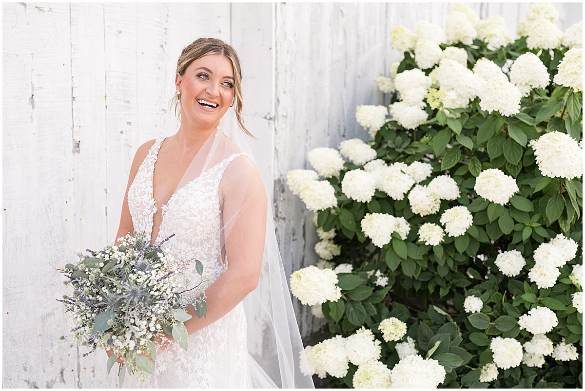 Bride portrait next to white flowers at White Willow Creek Barn