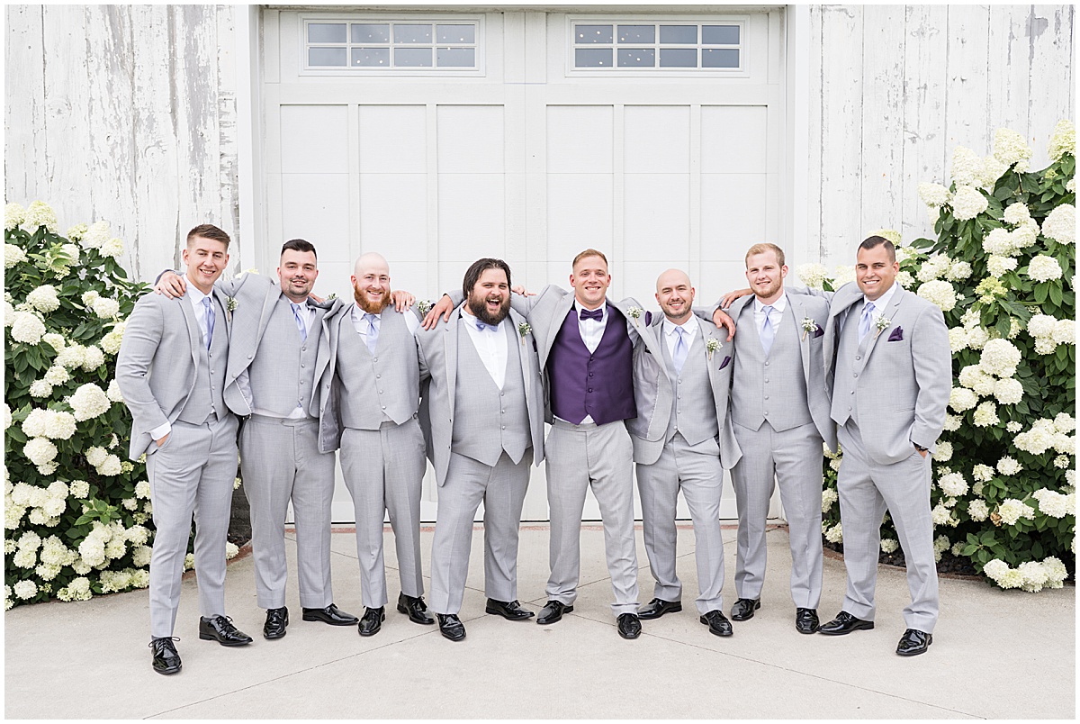 Groom hugs groomsmen at White Willow Creek Barn wedding in Frankfort, Indiana