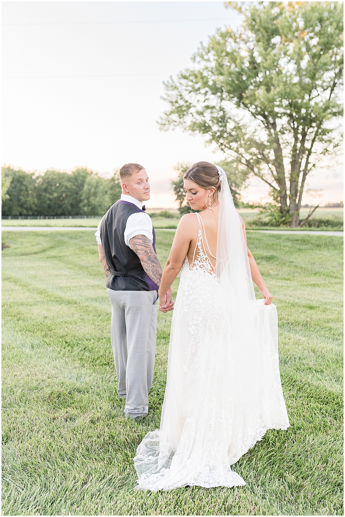 Bride and groom hold hands during sunset portraits at White Willow Creek Barn wedding in Frankfort, Indiana
