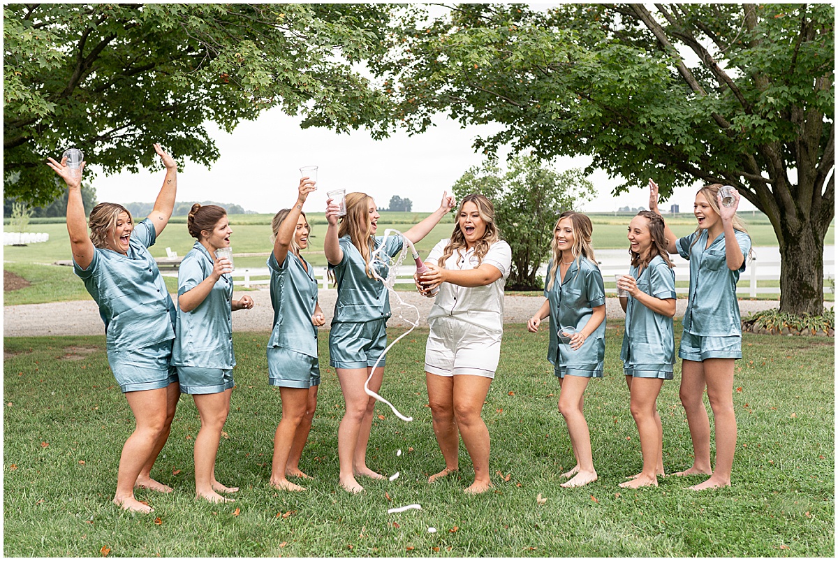 Bride pops champagne with bridesmaids before private property wedding in Peru, Indiana