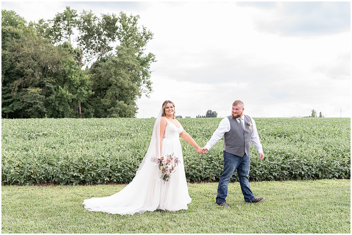 Newlyweds walk by field after private property wedding in Peru, Indiana