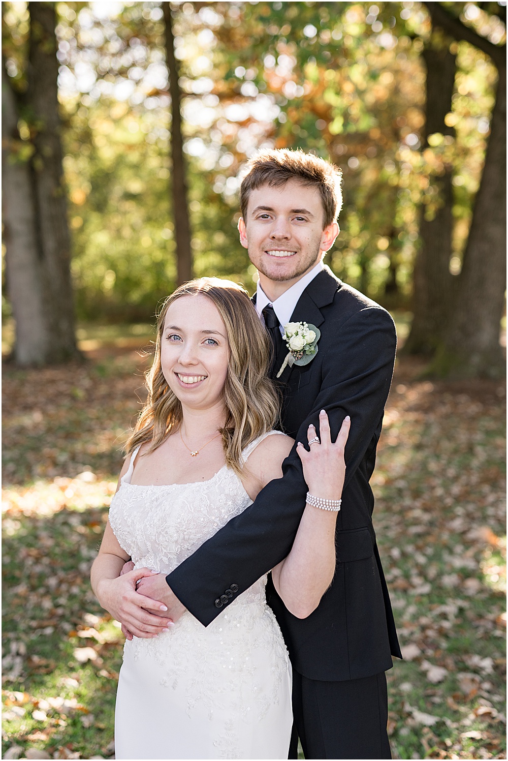 Bride and groom smiling toward camera during wedding photos at Coxhall Gardens in Carmel, Indiana