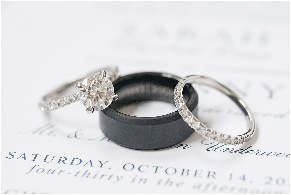 Close up of diamond and black rings at Lighthouse Restaurant wedding in Cedar Lake, Indiana