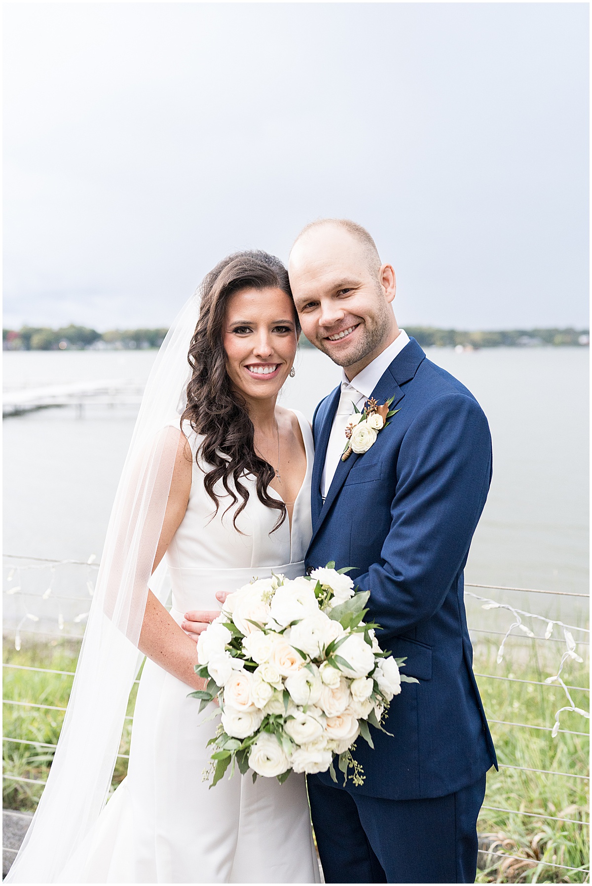 Newlyweds by lake after Lighthouse Restaurant wedding in Cedar Lake, Indiana