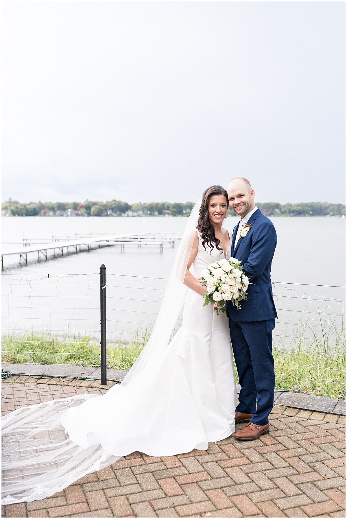 Bride and groom by lake at Lighthouse Restaurant wedding in Cedar Lake, Indiana