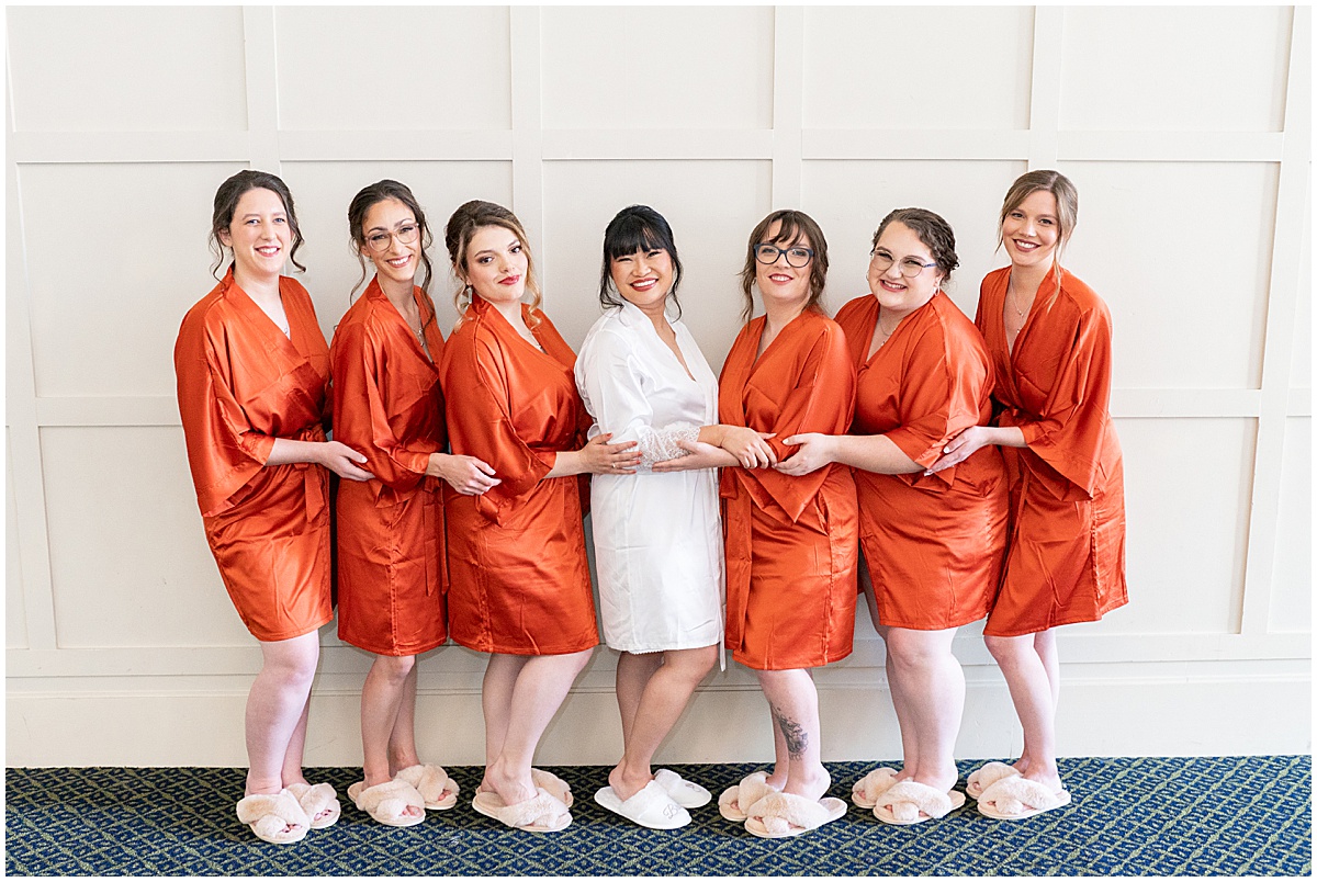 Bride with bridesmaids in orange robes before Union Station Illinois Street Ballroom wedding in downtown Indianapolis