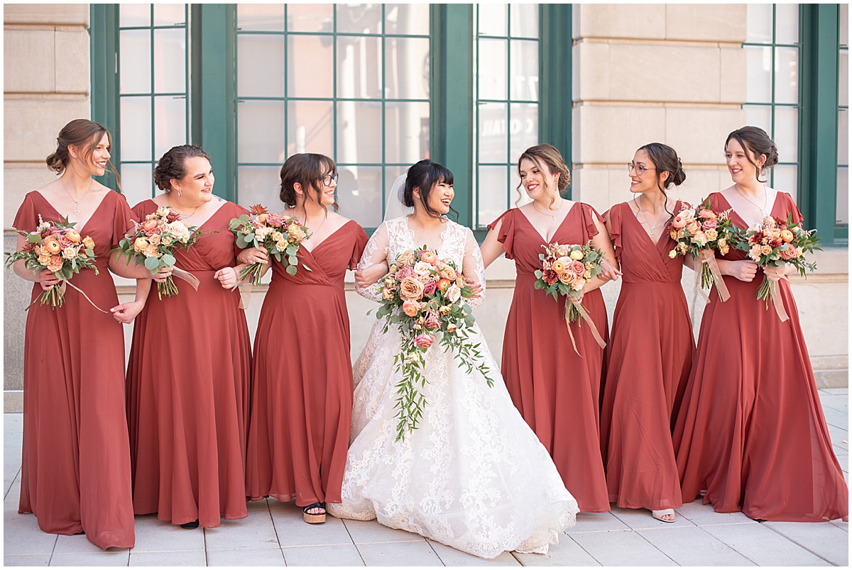 Bride with bridesmaids in burnt orange dresses in downtown Indianapolis
